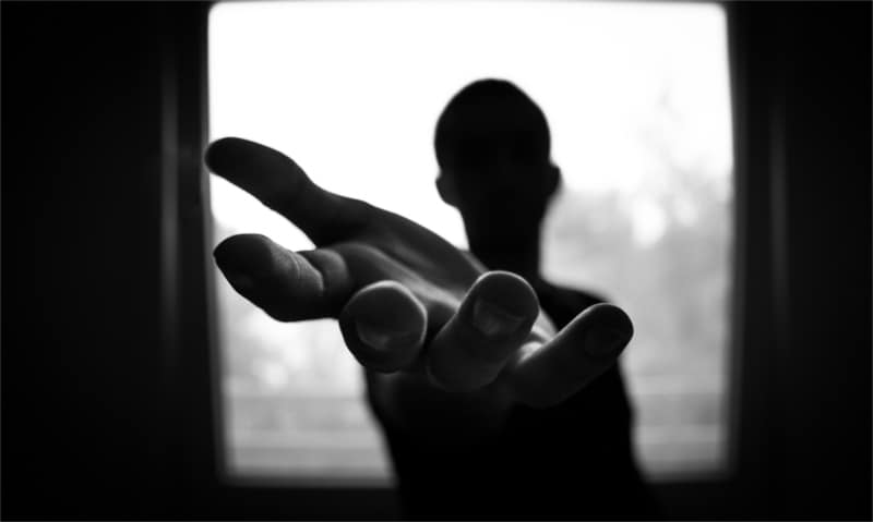 Osoba uzależniona wyciąga rękę po pomoc do ośrodka terapii uzależnień