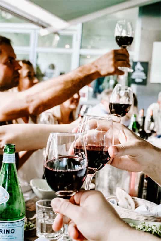 Kieliszki w rękach osób podnoszących toast - podczas imprezy nikt nie zastanawia się kiedy zaczyna się problem z alkoholem